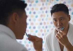Patient in Lincoln brushing their teeth in mirror