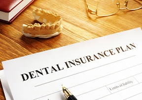 Dental insurance coverage documents on table