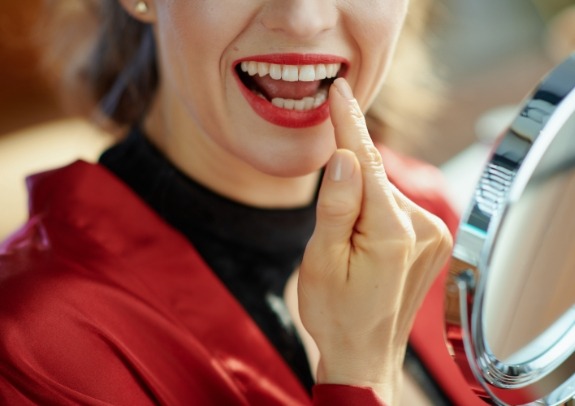 Woman pointing to smile after cosmetic dental bonding