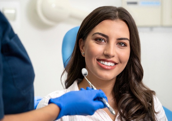 Woman smiling after receiving dental crowns in Lincoln