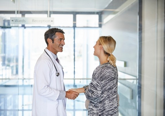 Dentist shaking hands with patient