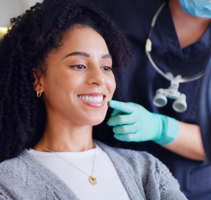 Patient smiling in mirror after dental treatment