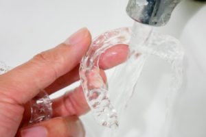 person running ClearCorrect aligner under water in sink