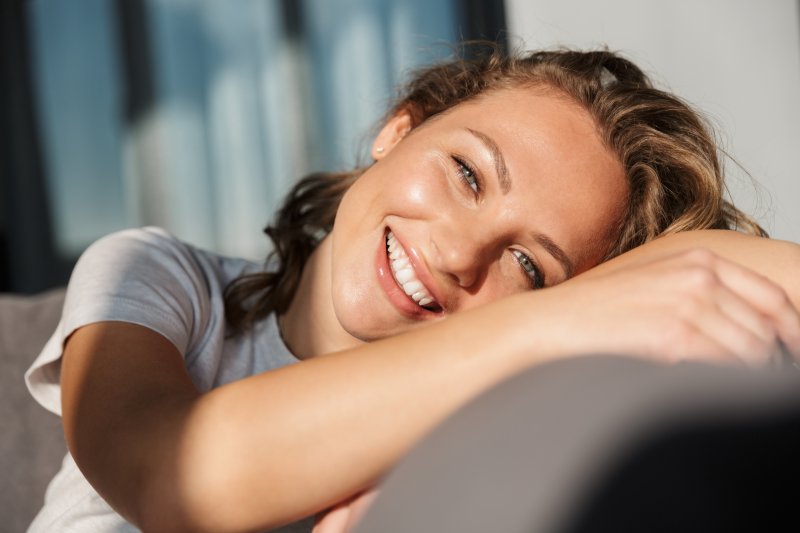 young woman on a couch showing off healthy smile