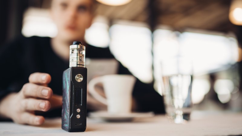 Patient who wants dental implants reaching for a vape