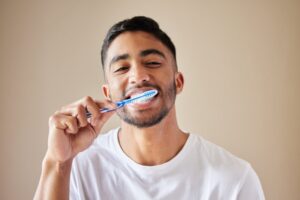 Young man brushing his teeth.
