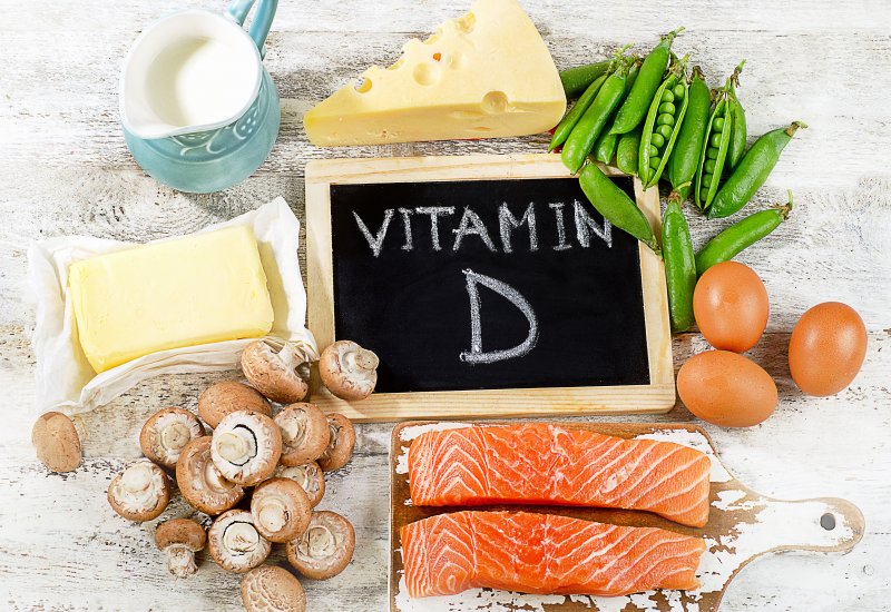 An array of foods rich in Vitamin D next to a blackboard